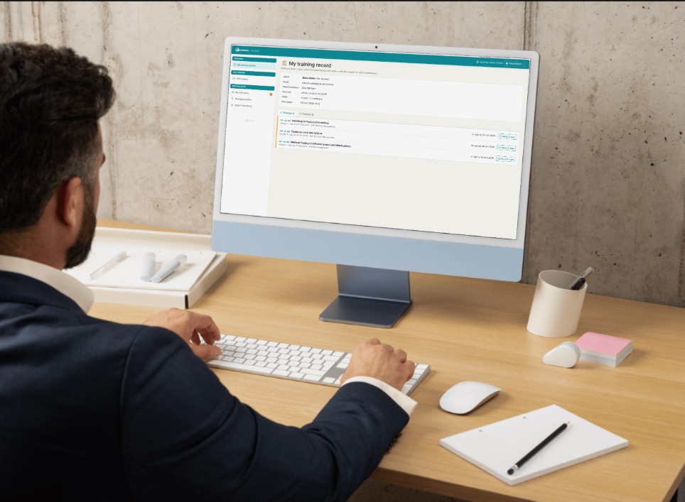Person at a desk working in OctoSOP, the screen shows the training record with SOPs to read and sign